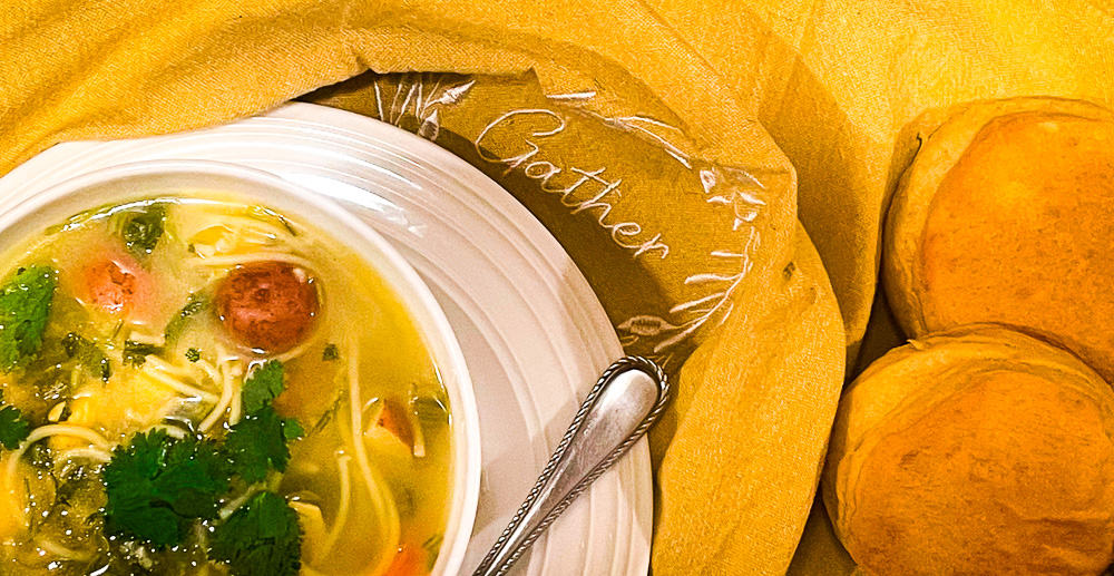 Lime and Cilantro Chicken Noodle Soup in a bowl with oven-baked biscuits.