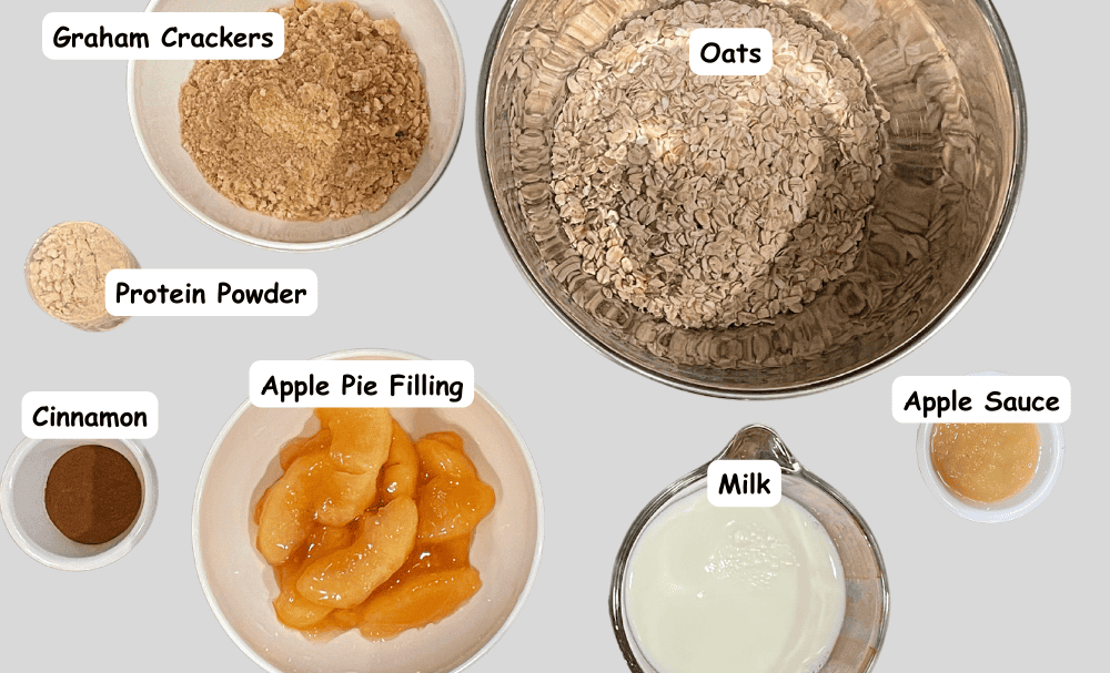 Apple pie overnight oats ingredients. Oats, milk, apple sauce, graham crackers, protein powder, cinnamon, apple pie filling. 